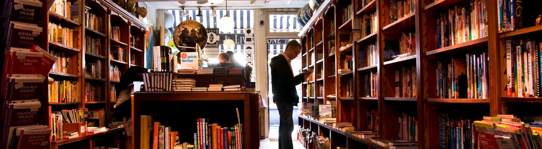 Inside the book shoppe with a man reading a book